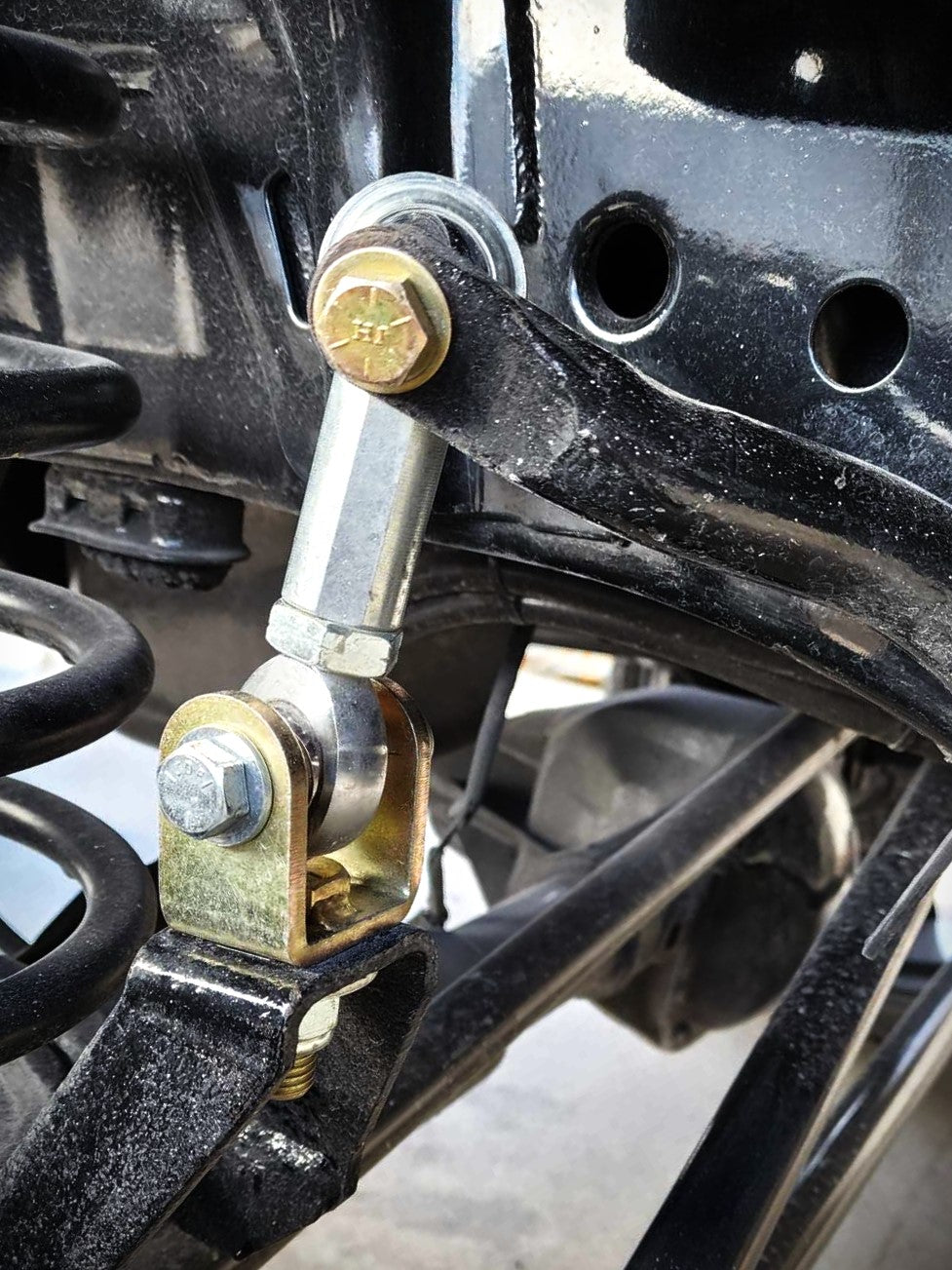 BKFabworks heavy-duty sway bar end link installed on 1994–2002 Dodge Ram 2500 front suspension, featuring heim joint and gold zinc hardware