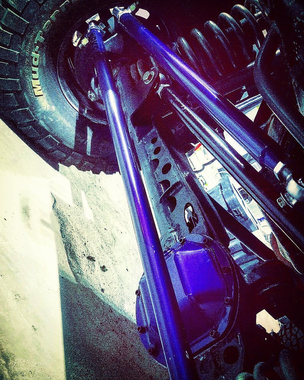 Custom BKFabworks front 3-link suspension setup with purple DOM control arms, high clearance mounts, and coil springs installed on solid front axle.