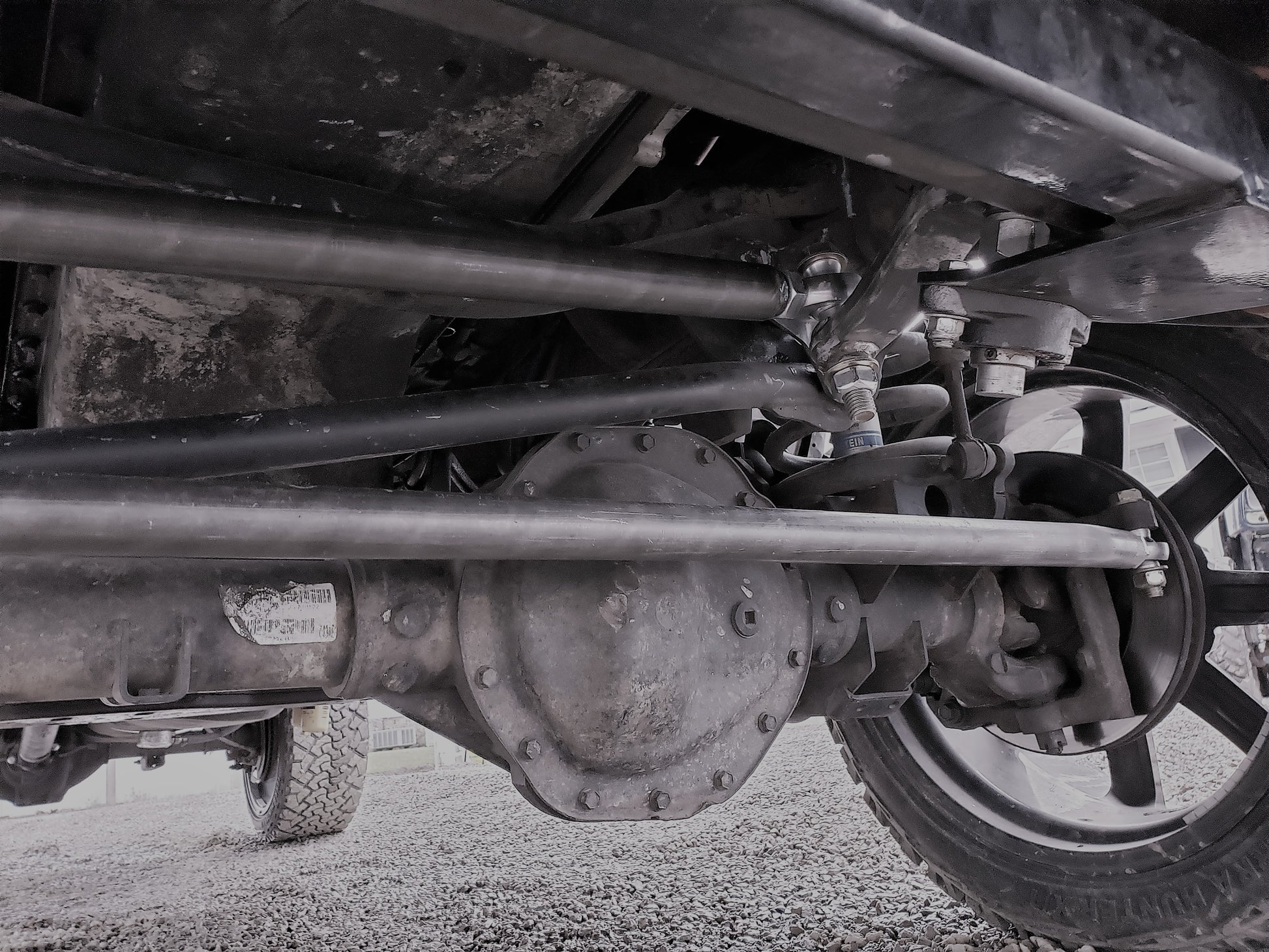 Underview of installed BKFabworks heavy-duty steering kit on Dodge Ram 2500/3500, showing tie rods, drag link, and steering stabilizer mount