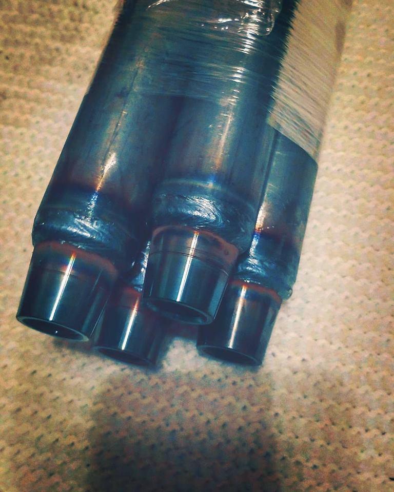 Close-up of BKFabworks welded DOM tube ends with bungs, prepped for steering or suspension assembly, partially wrapped for shipping