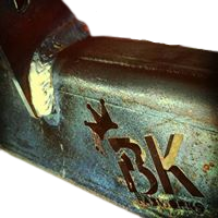 BKFabworks laser-cut logo on raw steel suspension bracket with weld seam detail
