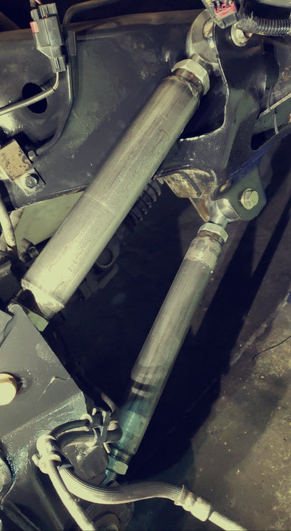 Close-up view of BKFabworks adjustable lower control arms installed on Jeep suspension with heim joints